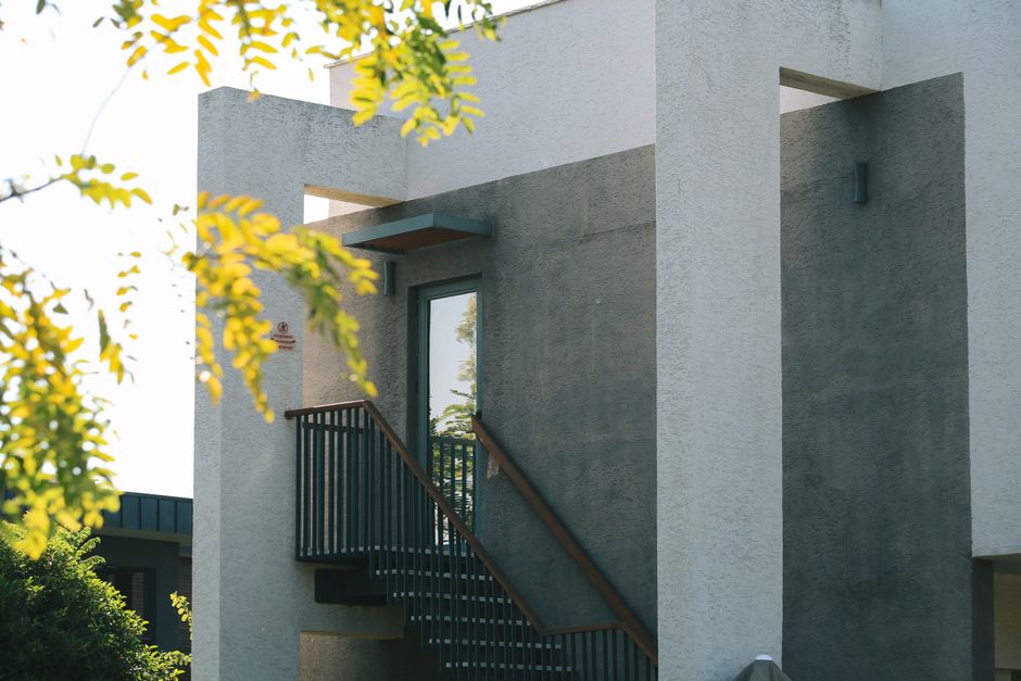 A row of modern townhouses with clean architectural lines basks in bright sunlight, representing a valuable real estate asset.