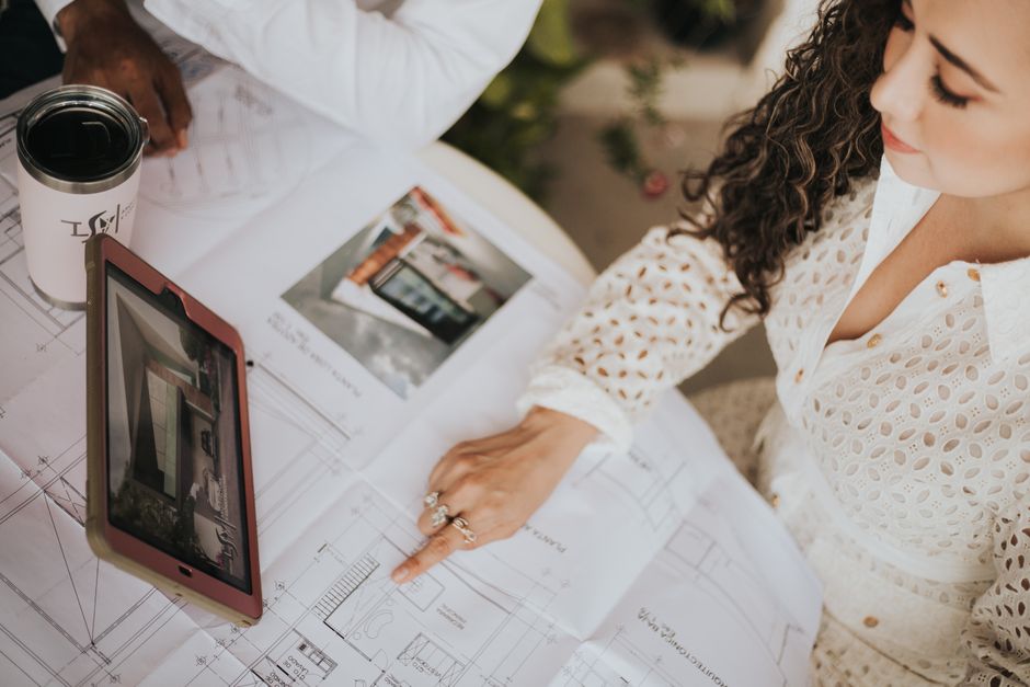 A close-up of a real estate team's hands reviewing property documents and blueprints on a clean, organized desk, showcasing expertise and a streamlined process.